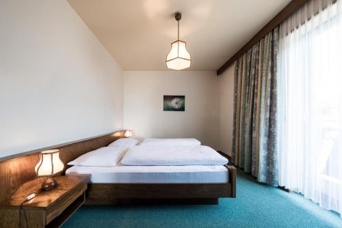 a bedroom with a bed and a large window at Apartments Feyerlin in Lana