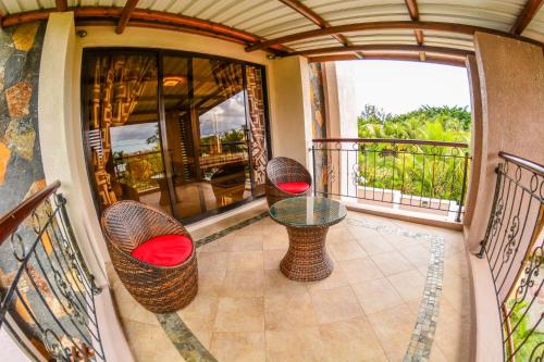 a balcony with two chairs and a glass table at Villa Chan in Tamarin