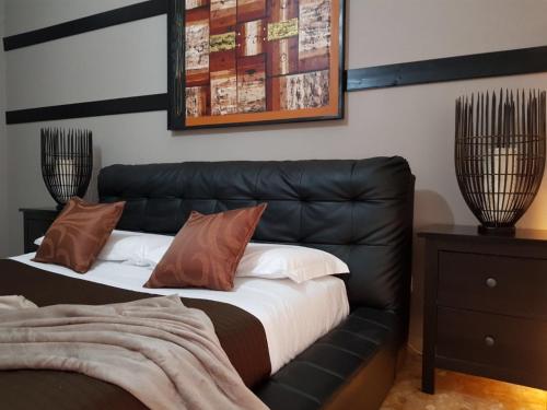 a black leather bed with brown pillows on it at 3Jolie in Verona