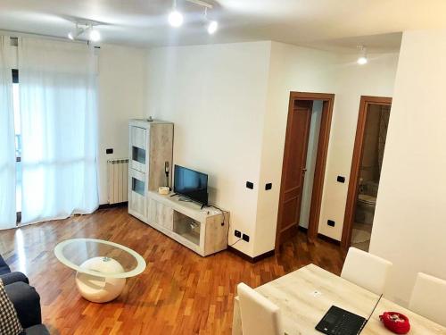 Sala de estar con sofá, TV y mesa en Domus Fiera di Roma Village, en Fiumicino