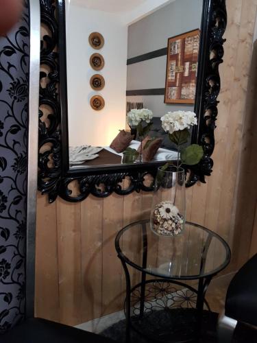 a mirror on a wall with a glass table at 3Jolie in Verona