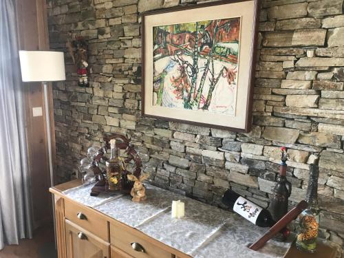 a stone wall in a room with a table and a picture at Pirin Golf Villa Emila in Bansko