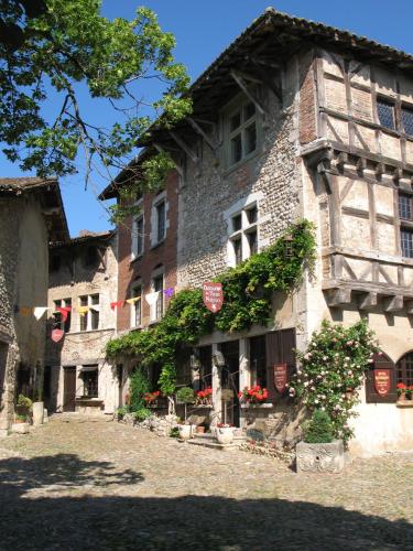 a large stone building with flowers in front of it at Hostellerie du Vieux Pérouges in Pérouges