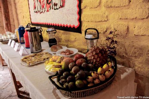 a table with a basket of fruit on it at Kyaninga Royal Cottage in Fort Portal