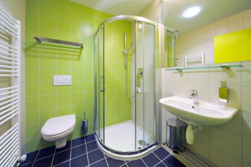 a bathroom with a shower and a toilet and a sink at Penzion Andula Friesovy boudy in Strážné