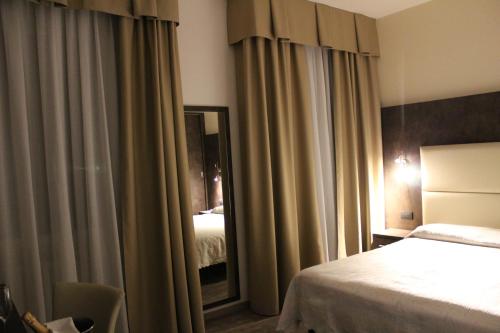 a hotel room with a bed and a mirror at Albergo Ristorante Miramonti Toano in Toano