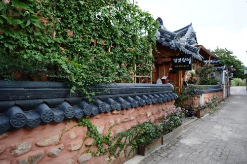 a brick wall with plants on it next to a building at Starlight Rest Area in Jeonju