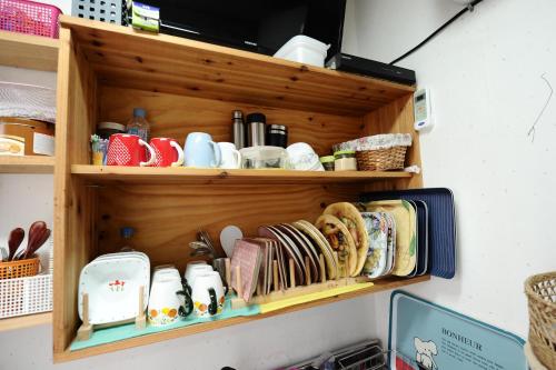 a shelf with cups and plates on it at Starlight Rest Area in Jeonju