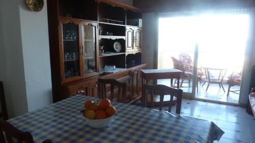 una cocina con una mesa con un bol de fruta. en Rodafam, en Playa de Miramar
