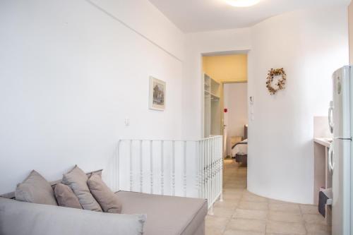 a white living room with a white couch at Anemomiloi Studios in Andros