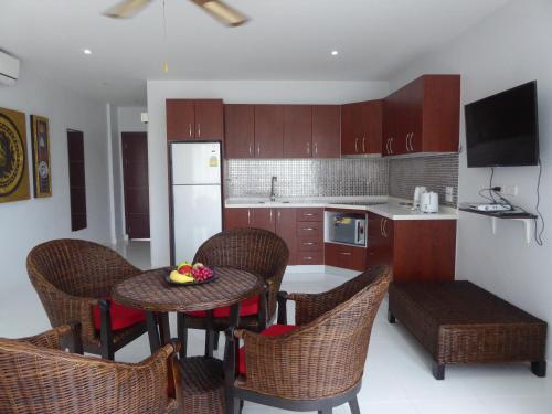 a kitchen with a table and chairs and a kitchen with a refrigerator at The Orchid Beach Resort @ VIP Chain Resort in Ban Phe