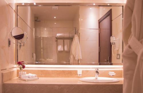 Golden Inn Hotel في القاهرة: حمام مع حوض ومرآة كبيرة