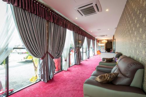 a row of couches in a room with windows at Hamilton Hotel Kajang in Kajang