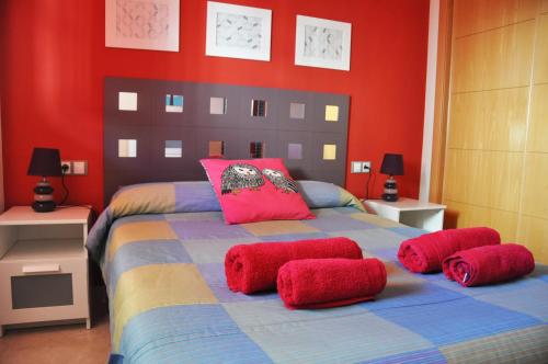 サン・ルイス・デ・サビニリャスにあるApartamento San Luisの赤い壁のベッドルーム1室(大型ベッド1台付)