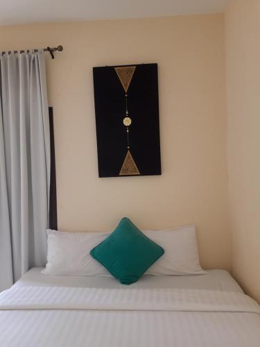 a bed with a clock on the wall above it at Classic home in Bang Tao Beach