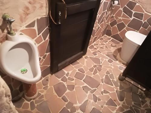 a bathroom with a urinal and a trash can at Taketomijima Guesthouse and je Taime in Taketomi