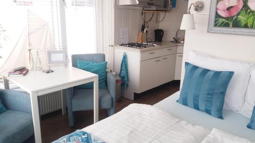 a small kitchen with a desk and a table in a room at Huize de Weijde Blick in Wijk aan Zee