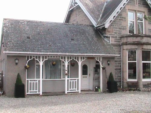a house with a white door and a porch at Avondale House in Kingussie