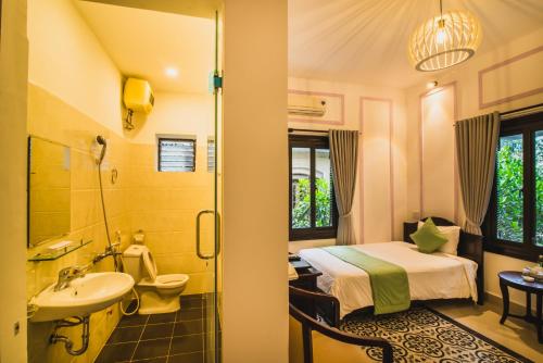 a bathroom with a bed and a sink and a toilet at Thien Phu Hotel in Hue