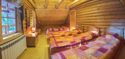 a room with three beds in a log cabin at Irvese Puhkemaja in Haanja