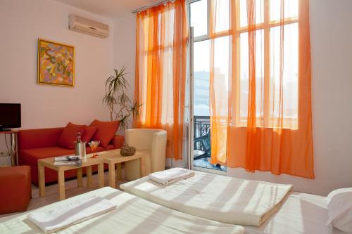 - un salon avec un lit, un canapé et une fenêtre dans l'établissement Scotty's Boutique Hotel, à Sofia