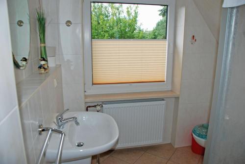 uma casa de banho com um lavatório e uma janela em Selliner Ferienwohnungen em Ostseebad Sellin