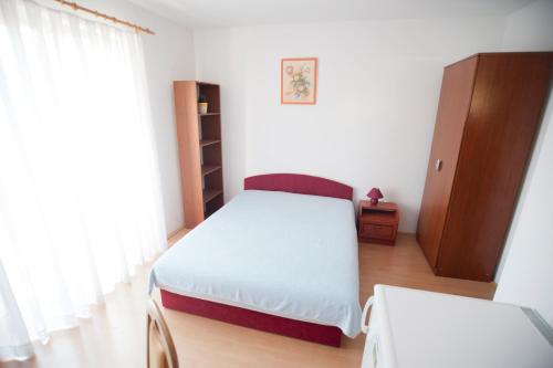 a small bedroom with a bed and a cabinet at Apartments Maric with parking in Umag