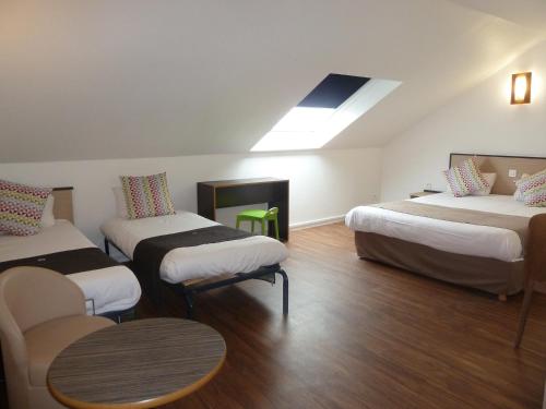 a room with three beds and a skylight at Campanile Le Mans Est in Le Mans