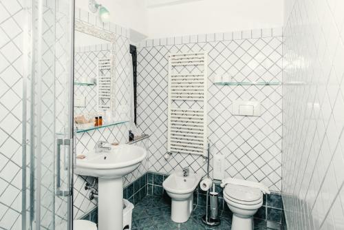 a white bathroom with a sink and a toilet at Casa Di Campagna In Toscana in Sovicille