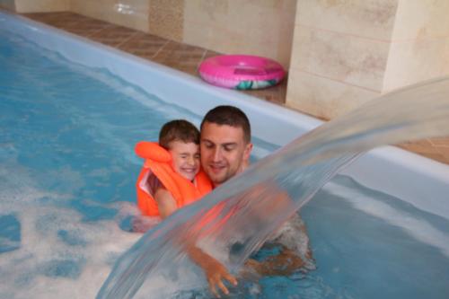 a man and a child in a swimming pool at Pensiunea Mușatinii in Putna