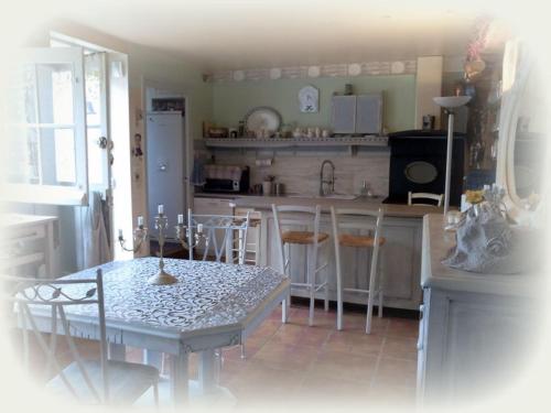 a kitchen with a table and a table and chairs at La Maison d'Hocquincourt in Bléneau