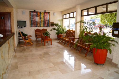 Un vestíbulo con un montón de sillas y plantas. en Hotel Veracruz, en Oaxaca City