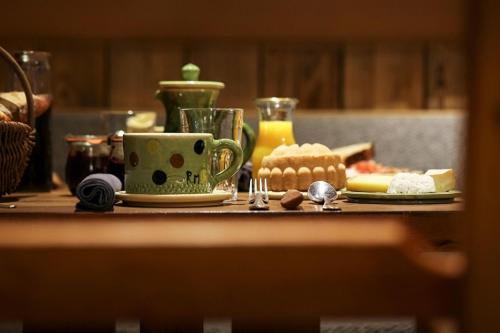 a table with a coffee cup and plates of food at La Bouitte - Hôtel Relais & Châteaux in Saint-Martin-de-Belleville