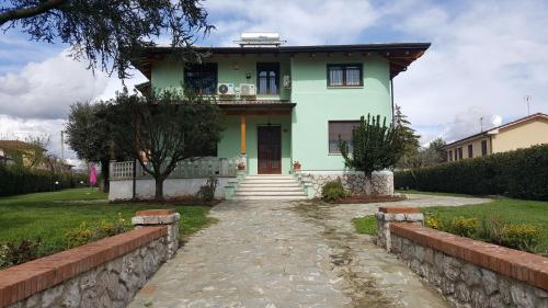 una casa verde con un camino de piedra delante de ella en Villa Franco, en Orentano