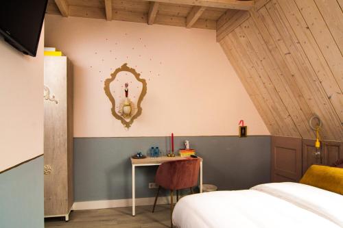 a bedroom with a bed and a table with a mirror at Herberg Swaen aan de Brink in Den Ham