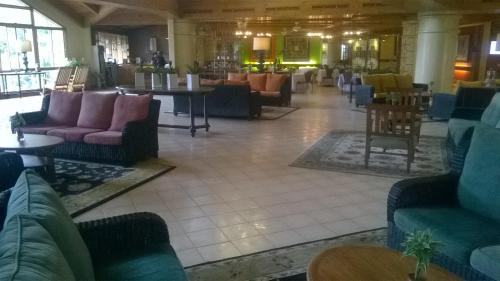 a lobby with couches and chairs in a building at PRIVATE suite AT CAMP JOHN HAY FOREST LODGE in Camp John Hay