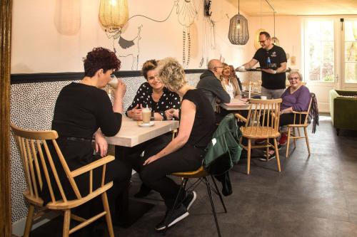 a group of people sitting at a table in a restaurant at Herberg Swaen aan de Brink in Den Ham