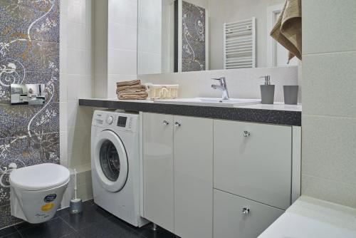een badkamer met een wasmachine en een wastafel bij D&A Apartments Old Town in Krakau