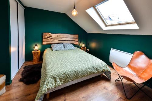 ein Schlafzimmer mit grünen Wänden, einem Bett und einem Stuhl in der Unterkunft Le Ch'ti Champenois in Épernay