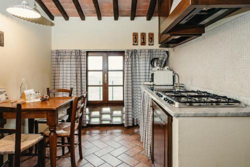 a kitchen with a table and a stove top oven at Casa Di Campagna In Toscana in Sovicille