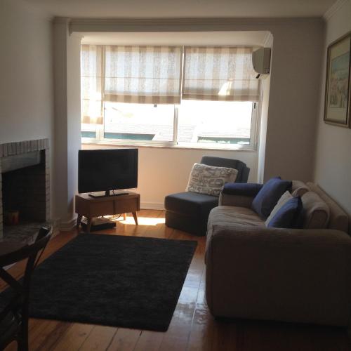 a living room with a couch and a large window at Campo de Ourique Premium in Lisbon