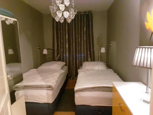 2 Betten in einem Zimmer mit Kronleuchter in der Unterkunft Ferienwohnung Kensche in Arnstadt