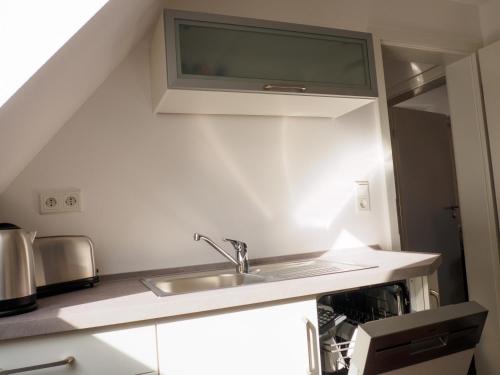 una cucina con lavello e microonde di Haus am Fluss a Baiersbronn
