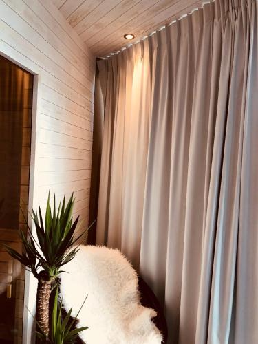 a white couch next to a window with a curtain at Mar y Luz in Koksijde