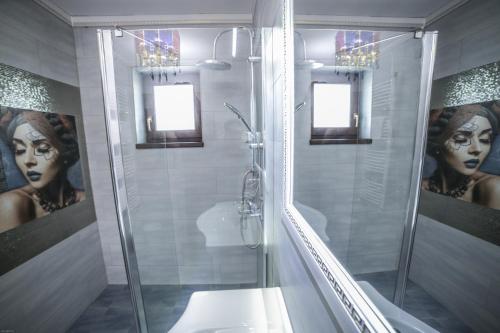 a bathroom with a shower with a painting of a woman at Studio B in Buftea