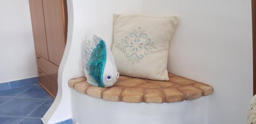 a blue fish sitting on a cushion next to a pillow at Sa Branda Costa Country Alghero in Santa Maria la Palma