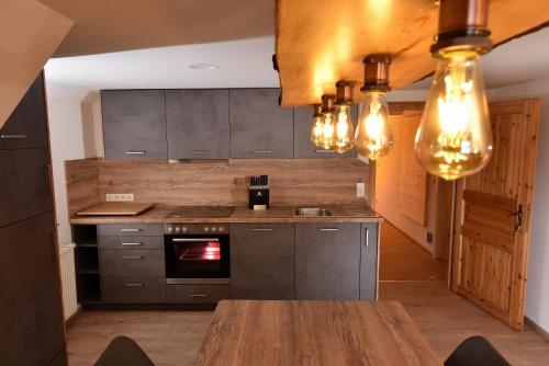 una cocina con una mesa de madera y algunas luces en Ferienwohnungen "Liftblick 2 oder 3" im Kurort Altenberg, en Kurort Altenberg