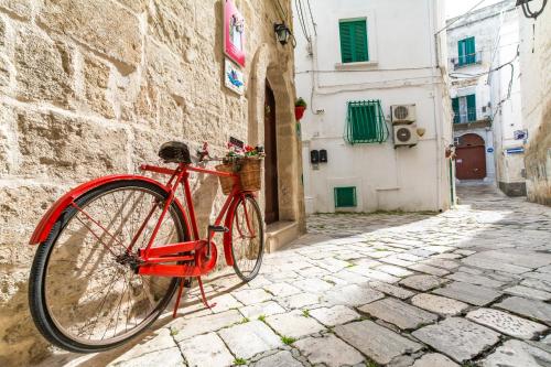 a red bike parked next to a stone alley at B&B Borgo San Martino in Monopoli