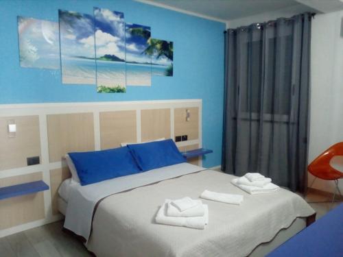 ポルトパーロにあるRooms STELLA POLAREの青い壁のベッドルーム1室(大型ベッド1台付)