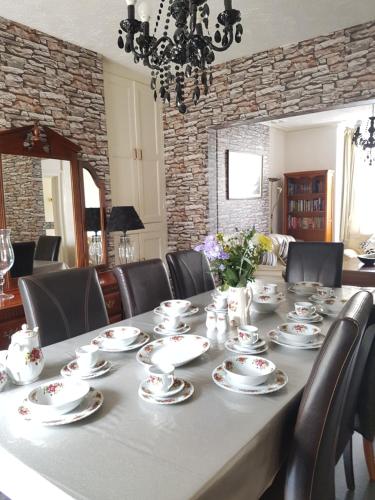 a dining room table with china dishes on it at Llandudno holiday home in Llandudno